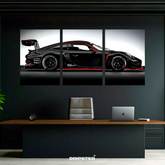Porsche 911 GT3 R poster set by Dripster featuring a sleek black race car split into three panels above a modern office desk