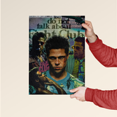Fight Club movie poster featuring main characters and iconic quote held by person in red sleeves
