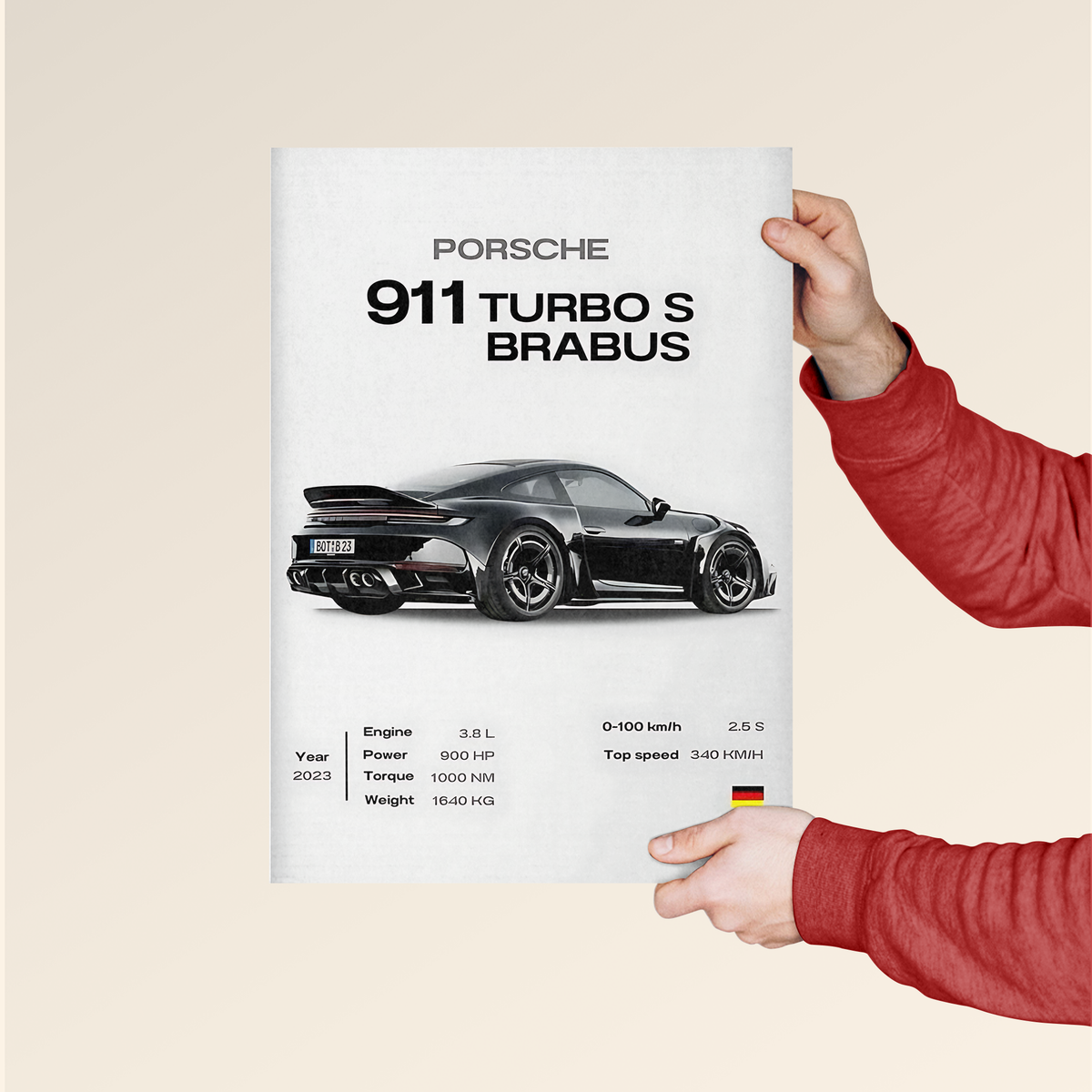 Porsche 911 Turbo S Brabus poster held by person in red sleeve featuring black sports car and specs