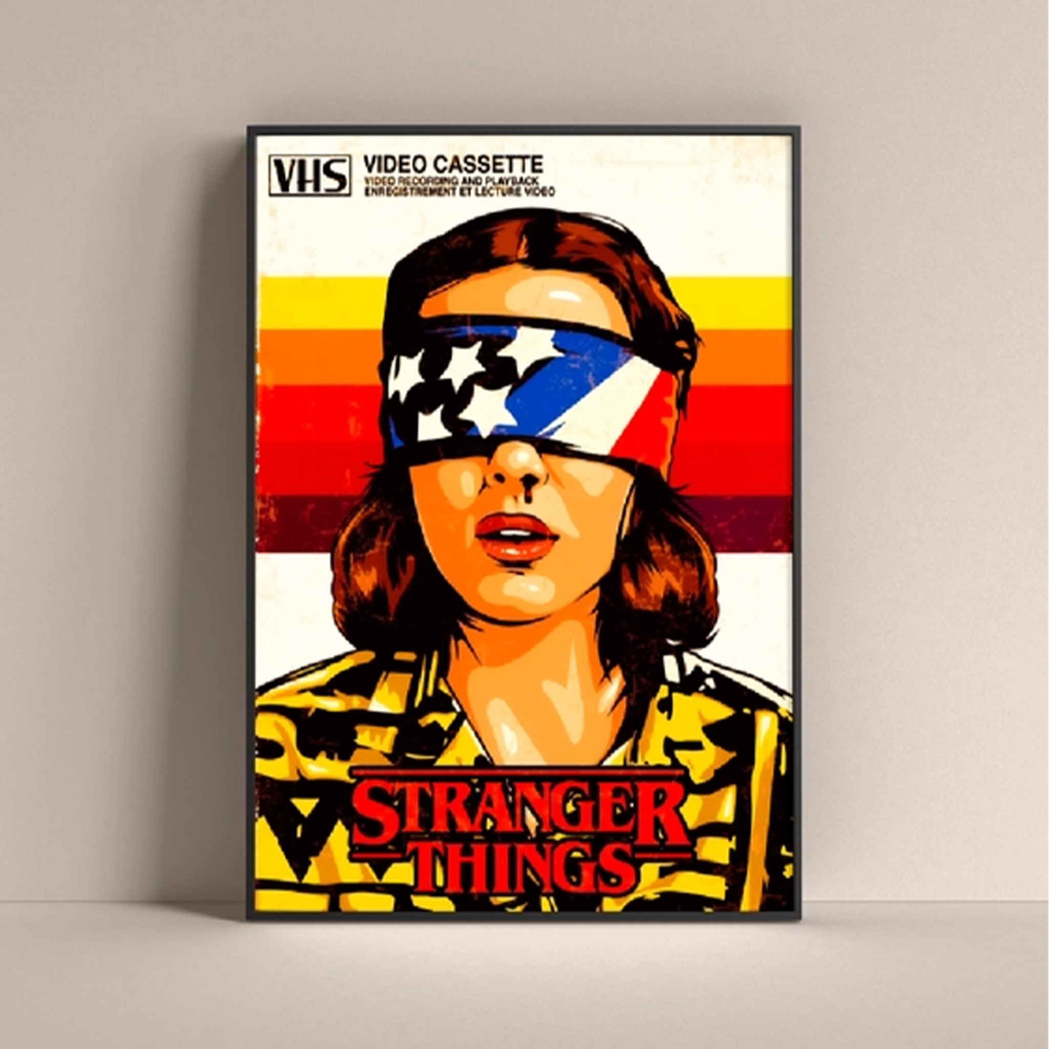 Stranger Things Eleven poster featuring a retro VHS design with bold colors and a blindfolded character